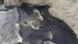 Tumpahan minyak menutupi pantai di pantai Cavero di Ventanilla, Callao, Peru, Senin (17/1/2022). Tumpahan minyak akibat gelombang tsunami yang dipicu letusan gunung api bawah laut di Tonga ini dikendalikan dalam beberapa jam namun, proses pembersihan masih terus berlangsung. (AP Photo/Martin Mejia)