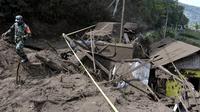 Seorang tentara berjalan melewati rumah-rumah yang rusak akibat tanah longsor yang dipicu gempa bumi di Bangli, di Bali, Sabtu (16/10/2021). Beberapa orang tewas dan lainnya luka-luka saat gempa berkekuatan sedang dan gempa susulan menghantam pulau itu Sabtu dini hari. (AP Photo/Dewa Raka)