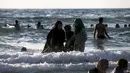 Sejumlah wanita Muslim bermain air di pantai Tel Aviv, Israel, Minggu (19/7/2015). Selama Idul Fitri, pemerintah Israel mengizinkan warga Palestina untuk berwisata di sepanjang garis pantai Mediterania. (REUTERS/Baz Ratner) 