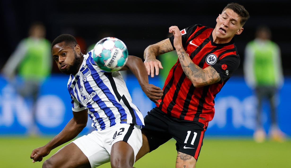 Gelandang Eintracht Frankfurt, Steven Zuber, berebut bola dengan bek Hertha Berlin, Deyovaisio Zeefuik, pada laga lanjutan Liga Jerman di Olympiastadion, Sabtu (26/9/2020) dini hari WIB. Frankfurt menang 3-1 atas Hertha Berlin. (AFP/Odd Andersen)