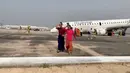 Penumpang berjalan meninggalkan pesawat Myanmar National Airline (MNA) yang mendarat tanpa roda depan di Bandara Internasional Mandalay, Myanmar, Minggu 12 Mei 2019. Pilot memutuskan untuk melakukan pendaratan darurat akibat roda depan pesawat gagal keluar. (Nay Min via REUTERS)