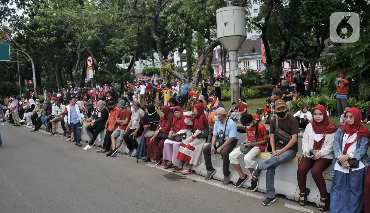 Warga melihat Upacara HUT ke-77 Republik Indonesia yang disaksikan dari Taman Aspirasi Monumen Nasional (Monas), Rabu (17/8/2022). Setelah sempat ditiadakan selama 2 tahun akibat pandemi Covid-19, Upacara Peringatan Kemerdekaan Republik Indonesia disambut antusias warga dari berbagai daerah yang berdatangan untuk mengikuti meski hanya dari luar Istana Negara. (merdeka.com/Iqbal S Nugroho)