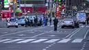 Petugas polisi terlihat sedang melakukan pemeriksaan di lokasi penembakan di Times Square di New York, AS (8/5/2021). Menurut laporan, tiga orang, termasuk seorang balita terluka dalam penembakan itu. (AFP/Kena Betancur)