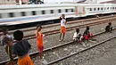Kereta melintas di kawasan Kemayoran, Jakarta, Senin (24/7). Minimnya lahan bermain menyebabkan anak-anak terpaksa bermain di lokasi tersebut, meskipun berbahaya bagi keselamatan. (Liputan6.com/Immanuel Antonius)
