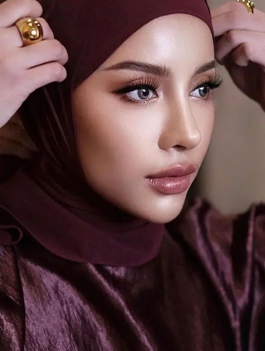 Ingin tampil sedikit lebih glamor di hari Lebaran? Ide makeup super cantik ala Aghnia Punjabi dengan glossy eyes dan lips bernuansa merah keunguan. [Foto: Instagram/emyaghnia]