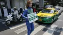 Seorang wanita anggota PETA saat melakukan aksi untuk mempromosikan veganisme di Bangkok tanggal 21 April 2016. Wanita ini mewarnai sekujur tubuhnya dengan cat sambil membawa papan bertulis "Go Vegan".(REUTERS / Jorge Silva)