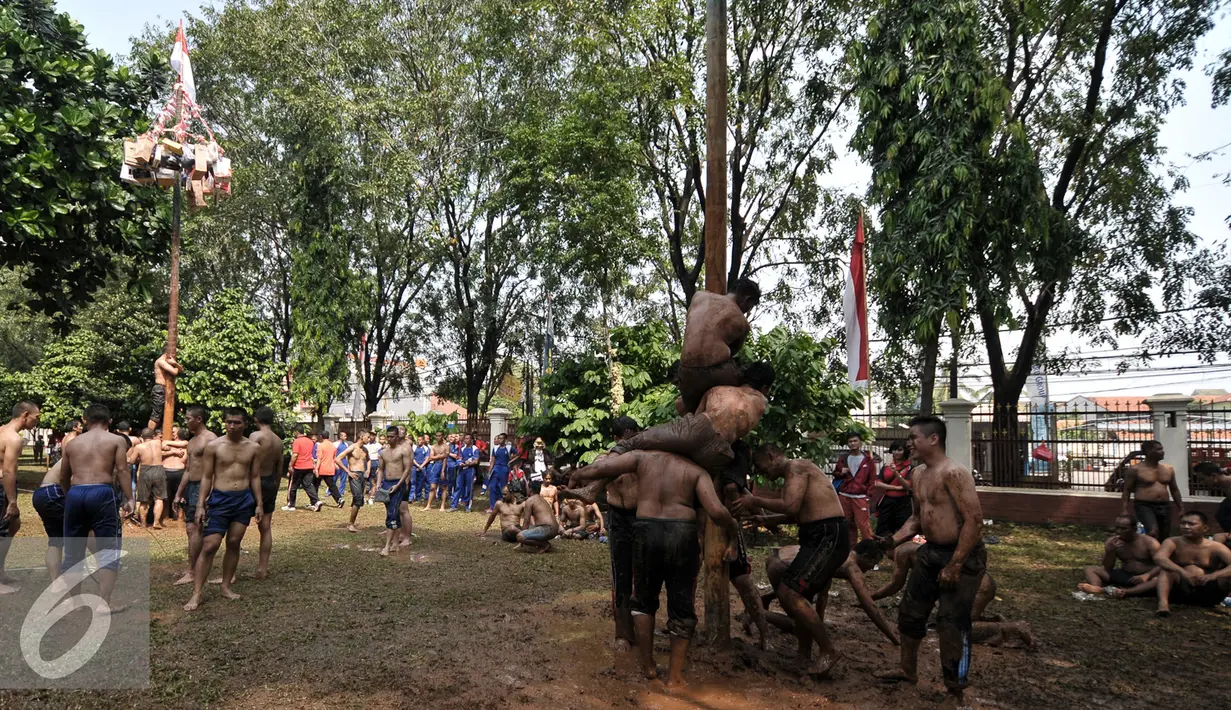 Peserta berusaha memanjat pohon pinang dalam acara semarak 17 Agustusan Kemenkumham di BPSDM Kemenkumham, Depok, Jumat (22/8). (Liputan6.com/Yoppy Renato)