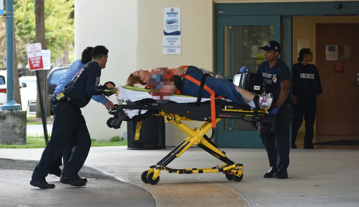 Penumpang yang terluka dibawa petugas saat kejadian penembakan yang dilakukan Esteban Santiago di bandara Fort Lauderdale, Florida, AS (6/1). (Taimy Alvarez /South Florida Sun-Sentinel via AP)