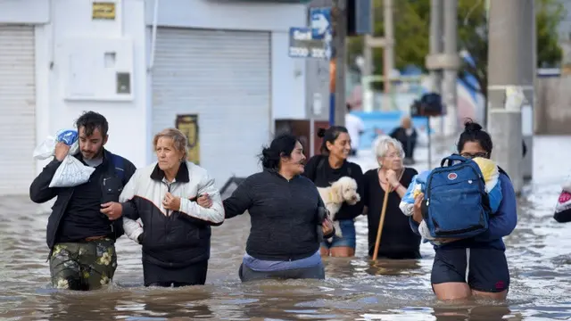 Orang-orang berjalan melewati banjir di Bahia Blanca, Argentina pada 8 Maret 2025 (PABLO PRESTI/AFP)