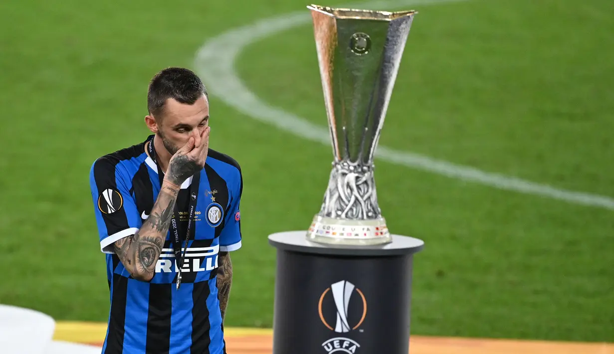 Pemain Inter Milan, Marcelo Brozovic, berjalan melewati trofi Liga Europa 2019/2020 di Stadion RheinEenergie, Sabtu (22/8/2020) dini hari WIB. Inter Milan kalah 2-3 atas Sevilla. (AFP/ Ina Fassbender/pool)