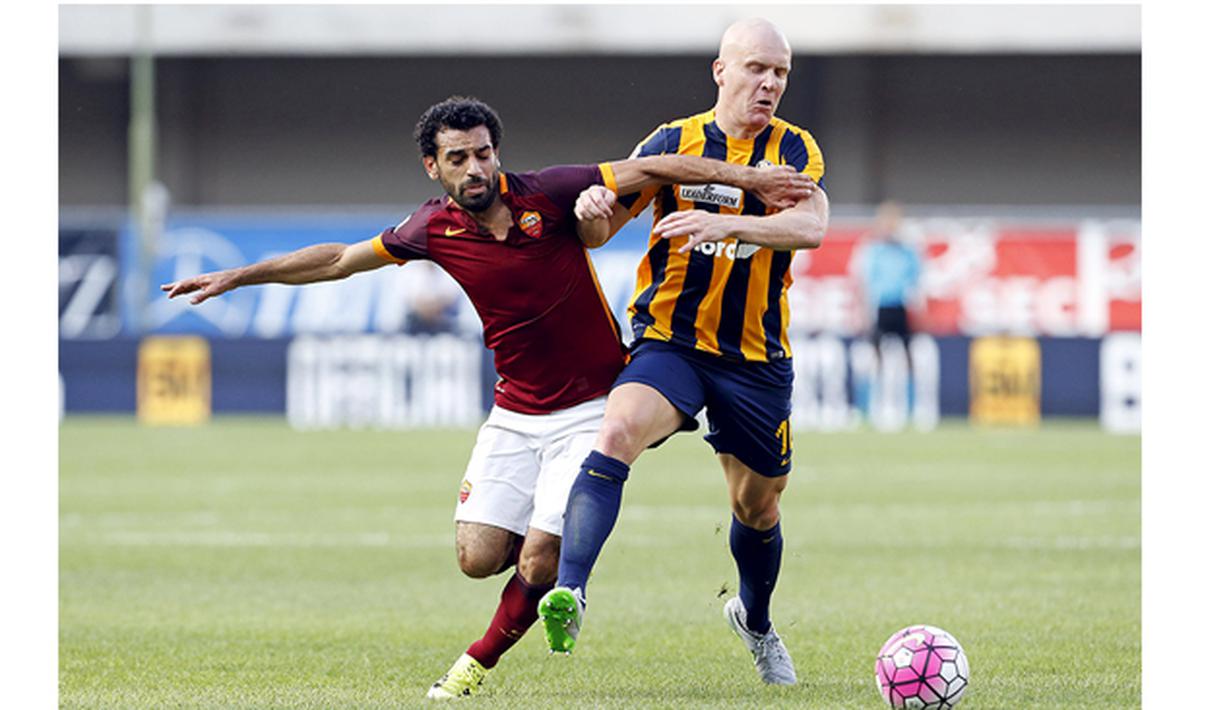 Pemain Roma, Mohamed Salah berebut bola dengan pemain Verona, Emil Hallfredsson di Stadion Marc'Antonio Bentegodi, Italia, Sabtu (22/8/2015). Roma bermain imbang 1-1 dengan Verona. (Reuters/Giampiero Sposito)