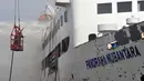 Pemadam kebakaran berusaha memadamkan api yang membakar kapal Panorama Nusantara di Pelabuhan Tanjung Mas, Semarang, Senin (18/2). Kepulan asap mulai kelihatan dari lantai atas kapal sekira pukul 11.30 WIB. (Liputan6.com/Gholib)