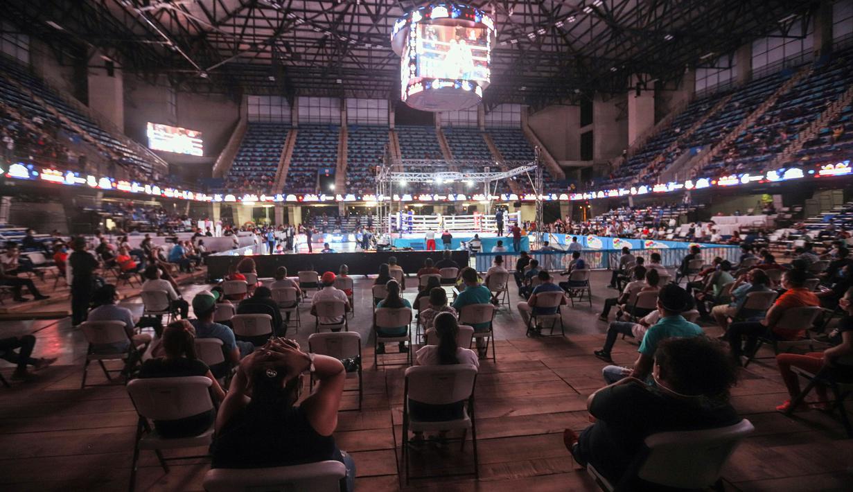 Penonton menerapkan jaga jarak saat melihat pertandingan tinju yang dipromotori oleh mantan juara dunia Rosendo Alvarez di Managua, Nikaragua pada 25 April 2020. Nikaragua merupakan salah satu dari sedikit negara yang kegiatan olahraga tetap berjalan di tengah pandemi Covid-19. (AP/Alfredo Zuniga)