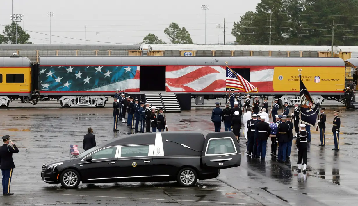 Anggota militer membawa peti jenazah Presiden ke-41 AS George HW Bush ke kereta di Union Pacific Westfield, Spring, Texas, Kamis (6/12). Kereta membawa jenazah George HW Bush menuju tempat peristirahatan terakhirnya. (AP Photo/Kiichiro Sato)