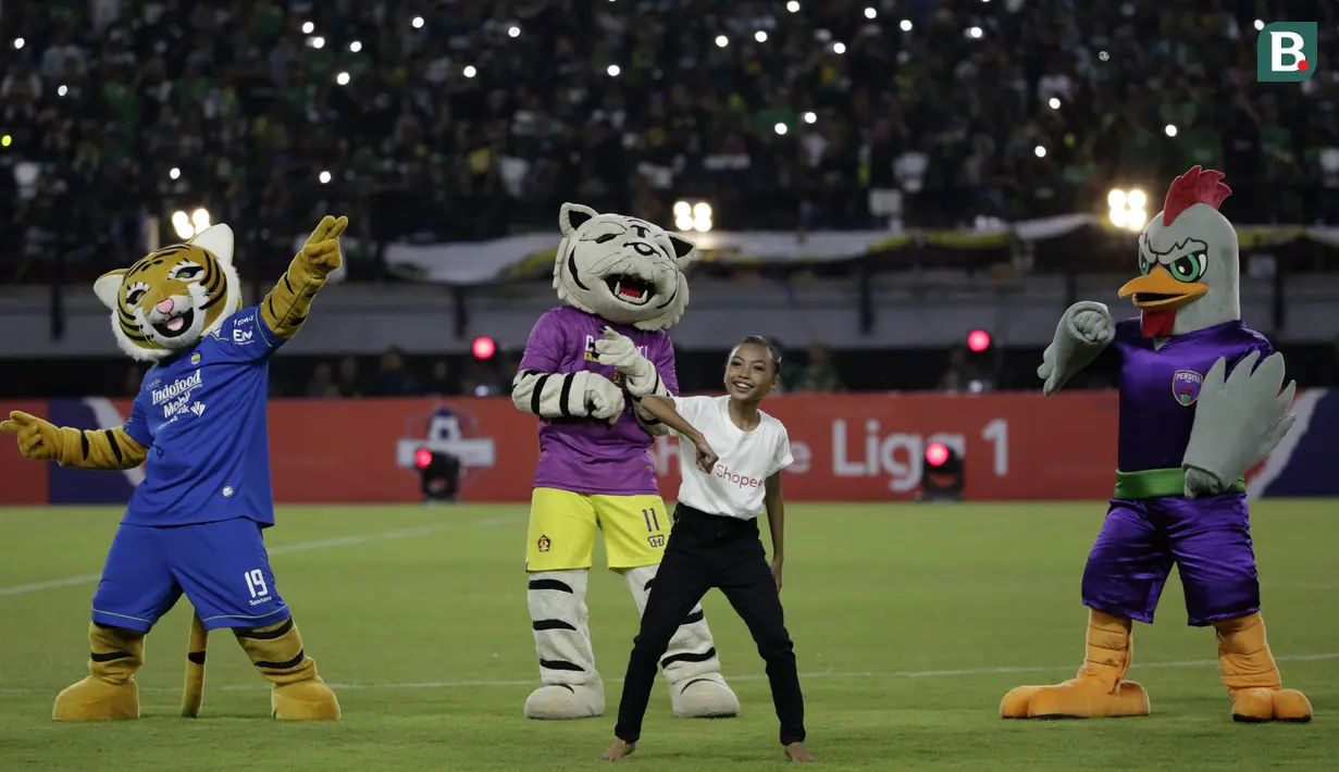 Seorang penari bersama maskot klub saat tampil pada pembukaan Shopee Liga 1 2020 di Stadion Gelora Bung Tomo, Surabaya, Sabtu (29/2). Sebanyak 18 klub akan berlaga dalam kompetisi kasta tertinggi di Indonesia ini.(Bola.com/Yoppy Renato)