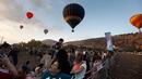 Sejumlah pengunjung menyaksikan Festival Balon Udara Gilboa di dekat Kibbutz Ein Harod, Lembah Jizreel, Israel (4/8). Festival balon udara ini menjadi tontonan menarik bagi warga sekitar dan wisatawan. (AFP Photo/Manahem Kahana)