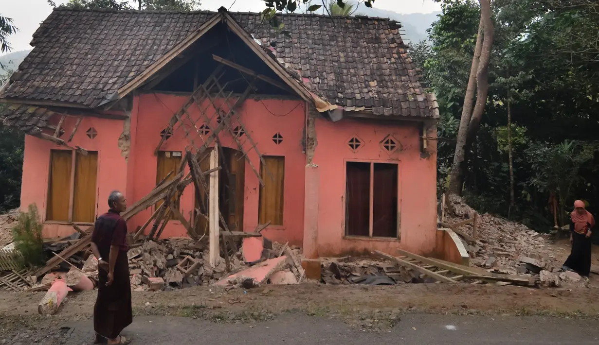 Warga melihat rumah yang rusak usai gempa melanda Pandeglang, Banten, Sabtu (3/8/2019). Menurut data sementara BPBD, sebanyak 106 unit rumah di Kabupaten Pandeglang dan Lebak rusak usai gempa Banten berkekuatan magnitudo 6,9. (RONALD SIAGIAN/AFP)