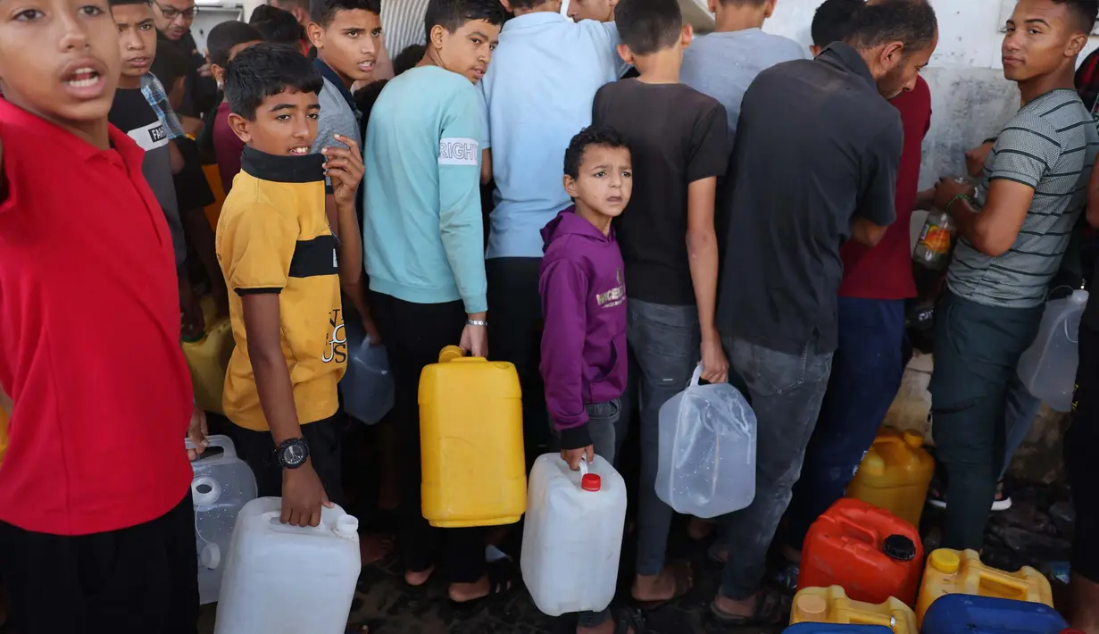Anak-anak pengungsi Palestina memegang wadah sambil menunggu waktu mengambil air, di Khan Yunis, di Jalur Gaza selatan pada 26 Oktober 2023. (MOHAMMED ABED/AFP)