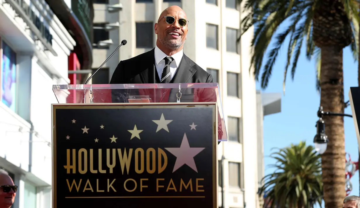 Aktor Dwayne Johnson menyampaikan pidatonya selama upacara penganugerahaan bintang Hollywood Walk of Fame  di Los Angeles, Jumat (13/12). (Photo by Willy Sanjuan/Invision/AP)