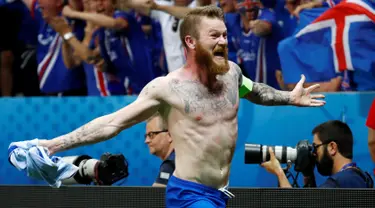 Kapten timnas Islandia, Aron Gunnarsson melakukan selebrasi dengan melepaskan jersey usai menyingkirkan Inggris di babak 16 besar Piala Eropa 2016, Selasa (28/6) dini hari. Inggris takluk 1-2 meski sempat unggul terlebih dahulu. (REUTERS/Michael Dalder)