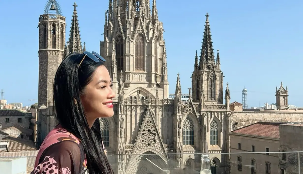 Dalam beberapa unggahannya, Titi Kamal terlihat berpose di depan Sagrada Familia dengan latar belakang menara-menara tinggi yang menjulang ke langit biru Barcelona. Mengenakan pakaian yang stylish, Titi tampak sangat menikmati momen-momen tersebut. Senyuman manisnya semakin menambah keindahan foto-foto tersebut, menunjukkan betapa bahagianya ia berada di sana. (Liputan6.com/IG/@titi_kamall)