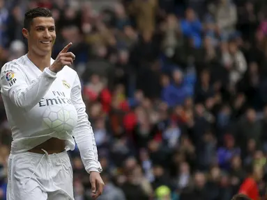 Cristiano Ronaldo melakukan selebrasi unik dengan memasukkan bola ke dalam kaosnya, Spanyol, Sabtu (5/3/2016). Ronaldo mencetak 4 gol saat menggilas Celta Vigo 7-1 di Santiago Bernabeu pada jornada 28 La Liga 2015/16. (Reuters/Susanna Vera)  
