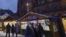 Pembeli yang mengenakan masker berjalan-jalan di pasar Natal di Strasbourg, Prancis, Jumat (26/11/2021). Prancis mengumumkan keputusan suntikan Booster Covid-19 untuk semua orang dewasa agar tak lagi menerapkan pembatasan wilayah, atau batasan jam malam. (AP Photo/Jean-Francois Badias)
