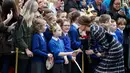 Kate Middleton bersalaman dengan salah seorang siswa dari sekolah St Philip dalam kunjungan ke Museum Nasional Sepakbola di Manchester, Inggris, (14/10). Kate tampil cantik didampingi suaminya Pangeran Wiliam. (Reuters/Phil Noble)