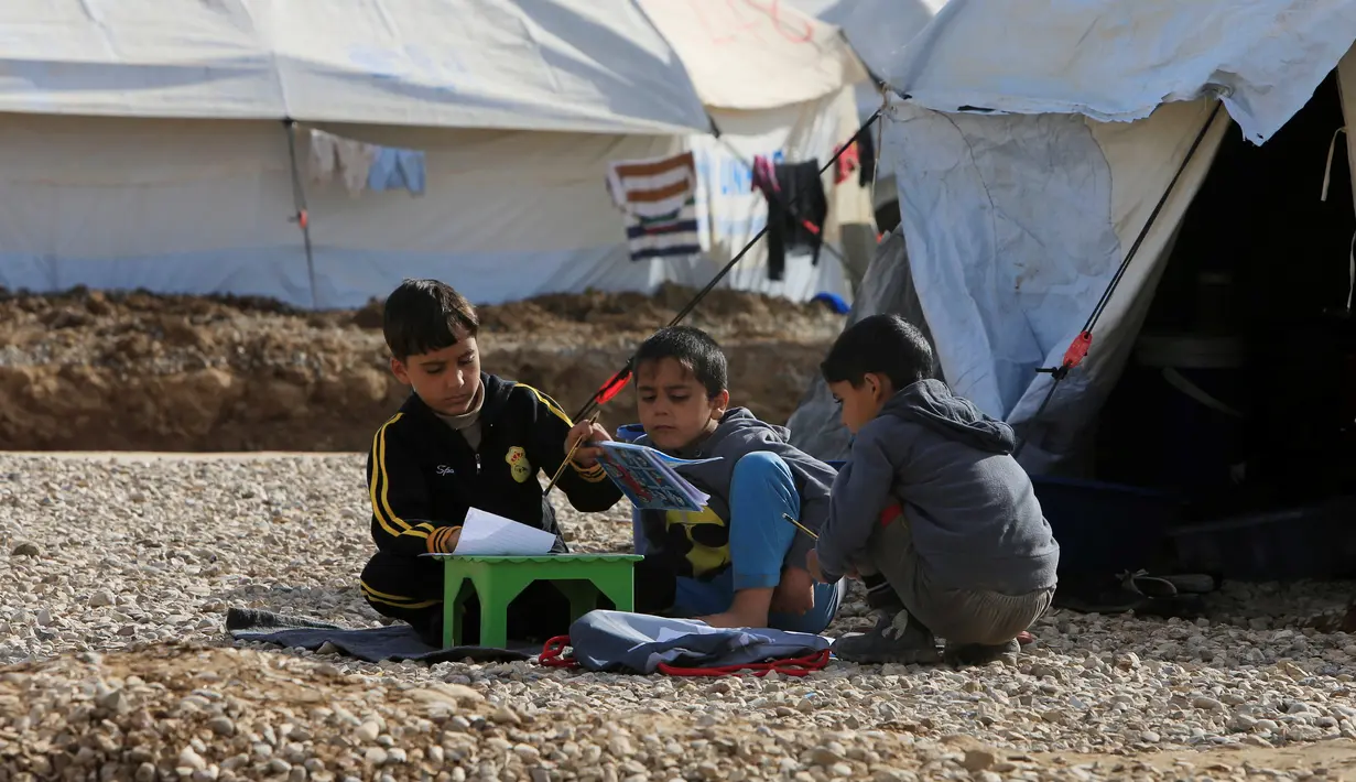Anak-anak pengungsi Irak terlihat tetap belajar di kamp Khazer, Irak (5/12). Mereka melarikan diri akibat konflik peperangan antara pasukan koalisi Irak dengan ISIS. (REUTERS / Alaa Al-Marjani)