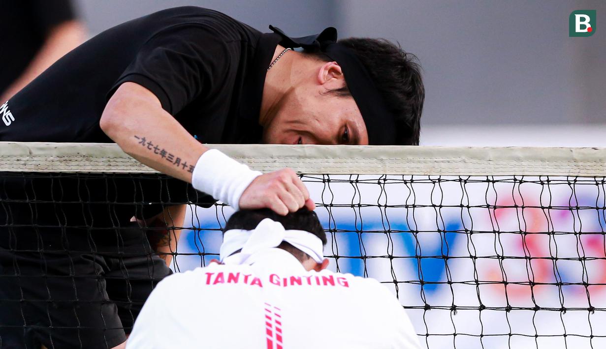 Selebritas Indonesia, Deddy Mahendra Desta mengusap kepala Tanta Ginting pada laga tenis nomor ganda putra Turnamen Olahraga Selebriti Indonesia di GOR UNJ, Jakarta, Minggu (30/07/2023). Desta yang berpasangan dengan Raffi Ahmad menang dengan skor 4-6, 6-4, dan 6-4. (Bola.com/Bagaskara Lazuardi)