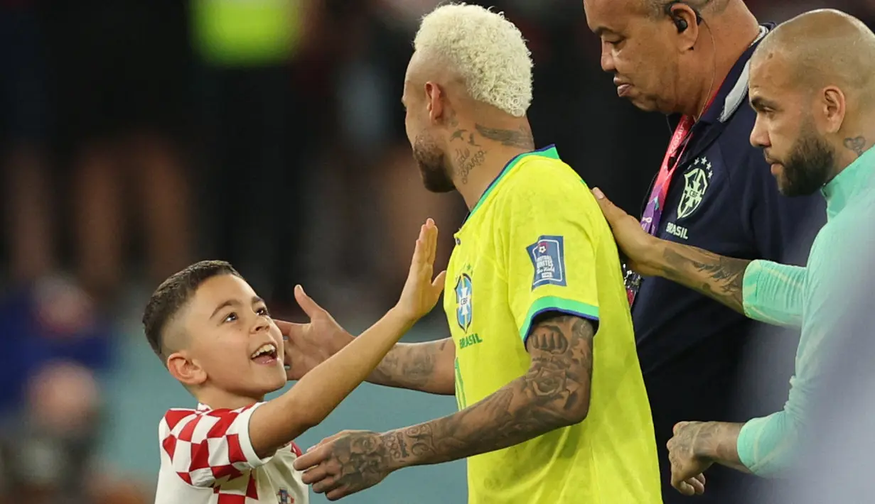 Penyerang Brasil #10 Neymar (Tengah) dihibur oleh putra gelandang Kroasia #04 Ivan Perisic setelah kalah pada perempat final Piala Dunia 2022 di Stadion Education City, Sabtu (10/12/2022) dini hari WIB. Brasil harus gigit jari usai tersingkir dari Piala Dunia 2022 setelah kalah adu penalti dari Kroasia 2-4. (Adrian DENNIS / AFP)
