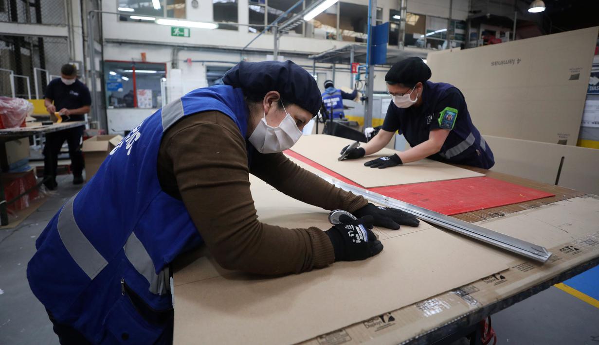 Pekerja sebuah perusahaan mendesain kardus yang dapat berfungsi sebagai tempat tidur rumah sakit dan peti mati untuk pasien COVID-19 di Bogota, Kolombia, Jumat (8/5/2020). Perusahaan ini menanggapi kekurangan tempat tidur dan peti mati selama pandemi virus corona.  (AP/Fernando Vergara)