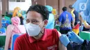 Vaksinator menyuntikkan vaksin COVID-19 Sinovac ke seorang guru saat vaksinasi massal di Gedung Pemerintah Kota Tangerang, Banten, Kamis (25/2/2021). Sebanyak 6.000 petugas pelayanan publik dan guru di Kota Tangerang menjalani vaksinasi COVID-19. (Liputan6.com/Angga Yuniar)