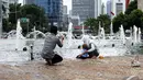 Sejumlah keluarga berfoto bersama di Bundaran Hotel Indonesia (HI), Jakarta, Kamis (1/1/2015). (Liputan6.com/Faizal Fanani)