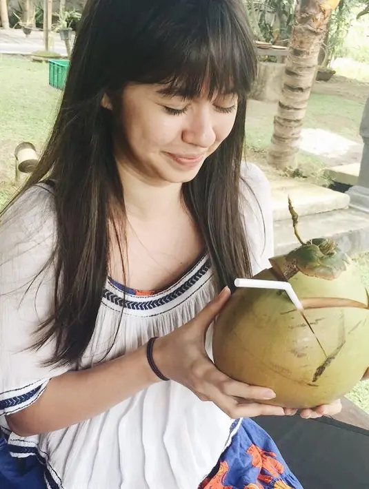Seperti ini contohnya, terliat sedang menikmati kelapa di tepi pantai, wajah Yuki terlihat begitu cantik alami tanpa make up di wajahnya. (Instagram/yukikt)
