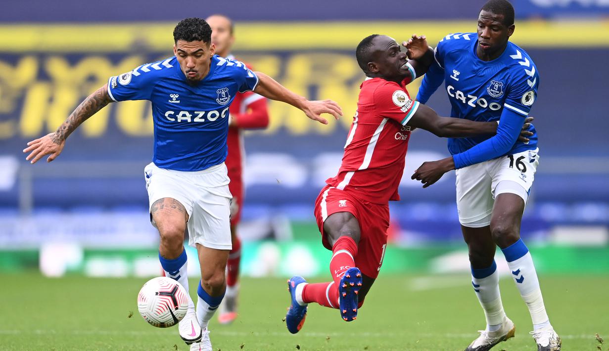 Penyerang Liverpool, Sadio Mane, berebut bola dengan gelandang Everton, Allan, pada laga lanjutan Liga Inggris di Goodison Park, Sabtu (17/10/2020) malam WIB. Liverpool bermain imbang 2-2 atas Everton.  (AFP/Laurence Griffiths/pool)