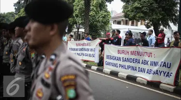 Para pengunjuk rasa membentangkan spanduk dijalan saat melakukan orasi di depan Kedutaan Besar Filipina, Jakarta, Kamis (14/7). Dalam aksinya mereka menuntut agar ABK WNI yang disandera di Filipina dibebaskan. (Liputan6.com/Faizal Fanani)