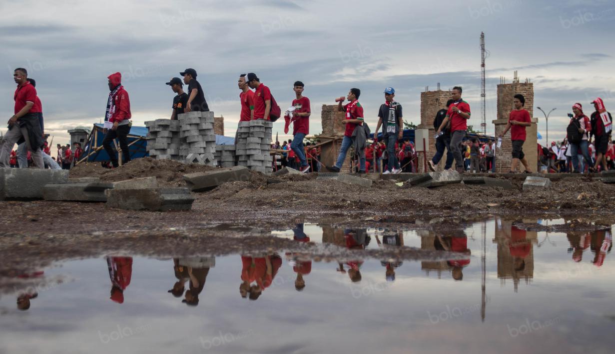 Meski harus berjalan jauh para suporter tetap semangat mendukung Timnas Indonesia yang akan bertanding melawan Vietnam di Stadion Pakansari, Jawa Barat, Sabtu (3/12/2016). (Bola.com/Vitalis Yogi Trisna)