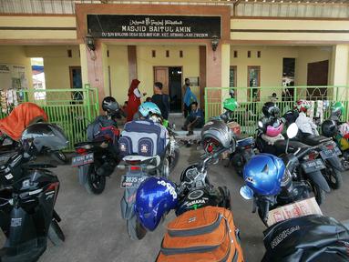 Pemudik sepeda motor beristirahat di sebuah masjid di Jalur Puntura, Jawa Barat, Minggu (2/6/2019). Masjid dan warung pinggir jalan jadi lokasi favorit pemudik sepeda motor melepas lelah saat melintasi Jalur Pantura (Liputan6.com/Herman Zakharia)