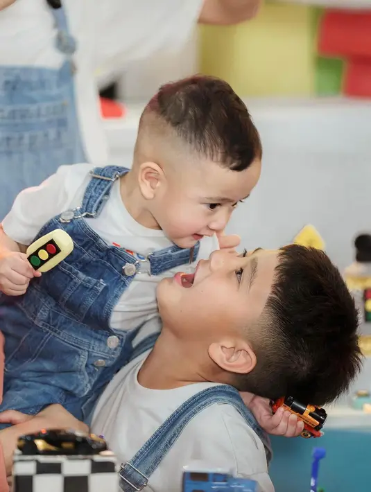 Gemasnya penampilan Rafathar dan Rayyanza mengenakan overall jeans. Keduanya memadukan kaus putih lengan pendek dengan overall jeans. [Foto: Instagram/raffinagita1717]