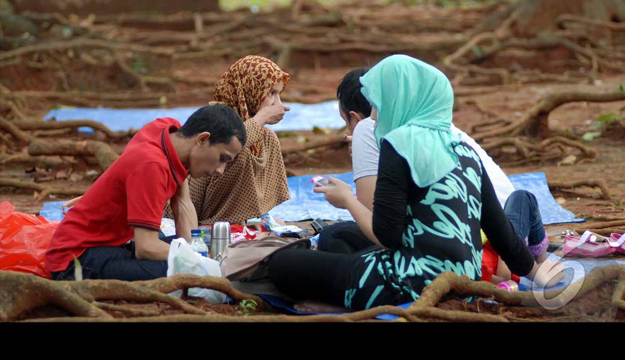 Sebuah keluarga sedang bersantai di sekitar taman Margasatwa Ragunan, Jakarta Selatan, Selasa (29/07/2014) (Liputan6.com/Miftahul Hayat) 