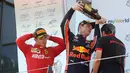 Pebalap Red Bull, Max Verstappen (tengah) menuangkan sampanye ke anggota staf tim usai memenangkan F1 GP Austria di Red Bull Ring, Spielberg, Minggu (30/6/2019). Max Verstappen menggeser Sebastian Vettel dari peringkat ketiga klasemen F1. (AP Photo/Ronald Zak)