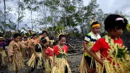 Warga adat Mah Meri berjalan menunju pantai untuk mengikuti ritual Puja Pantai di Pulau Carey, Malaysia (2/1). Warga Pulau Carey ini dipercaya merupakan keturunan pelaut. (AFP/Manan Vatsyayana)