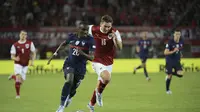 Penyerang Prancis, Moussa Diaby membawa bola dari kejaran pemain Austria, Maximilian Wober pada pertandingan grup A1 UEFA Nations League di Stadion Ernst Happel di Wina, Austria, Sabtu (11/6/2022). Dengan hasil ini, Prancis belum meraih kemenangan dalam tiga laganya di UEFA Nations League. (AP Photo/Michael Gruber)