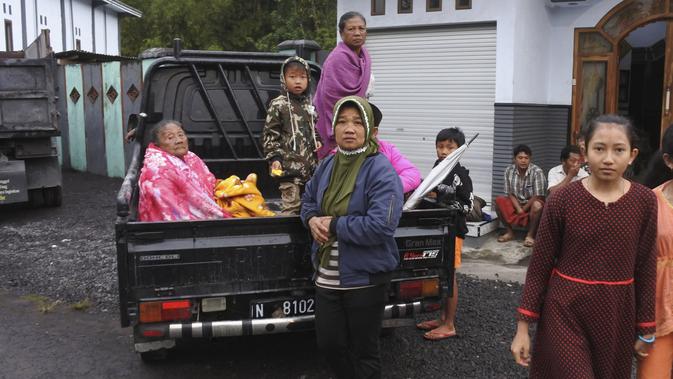 Wanita Indonesia duduk di belakang truk saat mereka bersiap untuk mengungsi dari rumah mereka setelah letusan Gunung Semeru di Lumajang, Jawa Timur, Indonesia, Selasa (1/12/2020). (AP Photo)