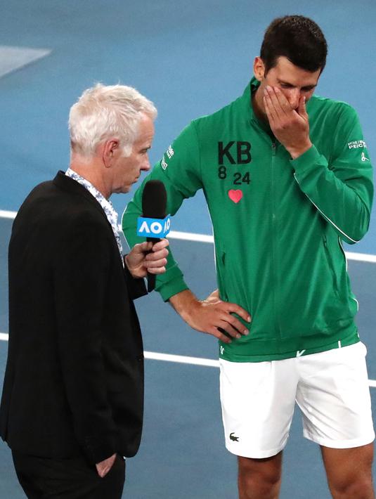 Reaksi Novak Djokovic saat diwawancarai tentang kematian Kobe Bryant usai mengalahkan Milos Raonic pada perempat final Australia Terbuka di Melbourne, Selasa (28/1/2020). Djokovic mengenakan jaket dengan inisial dan nomor punggung Kobe Bryant untuk menghormati temannya itu. (AP Photo/Dita Alangkara)
