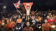 Suporter Persija Jakarta, The Jakmania, bergembira saat merayakan pesta juara Liga 1 di Bundaran Hotel Indonesia, Jakarta, Minggu (9/12). Persija unggul satu poin dari PSM Makassar di puncak klasemen. (Bola.com/Vitalis Yogi Trisna)