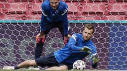 Kiper timnas Finlandia, Lukas Hradecky melompat untuk mengambil bola selama sesi latihan tim di stadion Parken di Kopenhagen, Jumat (11/6/2021). Timnas Denmark akan berhadapan dengan Timnas Finlandia pada laga pembuka Grup B Euro 2020, Sabtu (12/6) malam. (AP Photo/Martin Meissner)