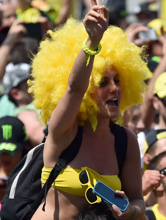 Seorang fans dari pebalap MotoGP, Valentino Rossi, menggunakan bikini dan rambut palsu untuk memberikan dukungan kepada idolanya pada GP Italia di Sirkuit Mugello, Italia, Minggu (31/5/2015). (AFP/Gabriel Bouys)
