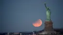 Pemandangan ketika Patung Liberty dihiasi oleh supermoon di Brooklyn, New York, Amerika Serikat, Rabu (31/1). Supermoon membuat purnama dan gerhana tampak lebih besar dari biasanya. (AP Photo/Julio Cortez)
